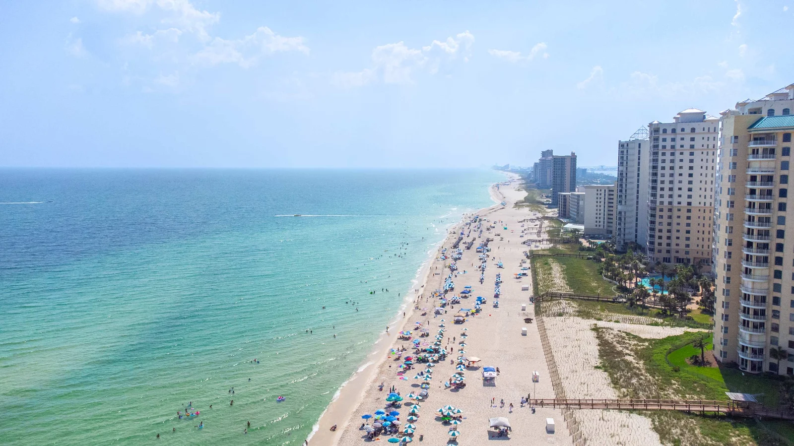 Aerial view of the Gulf Coast beach with emerald water, white sand, and the Pensacola area shoreline
