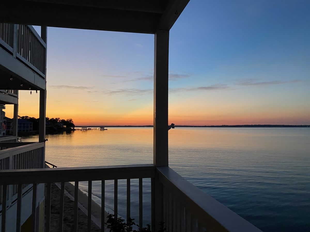 Sunset view from a LunaSol waterfront vacation rental balcony on Pensacola Bay