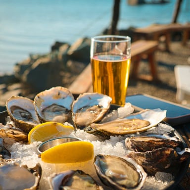 Fresh oysters on ice with beer at a waterfront bar