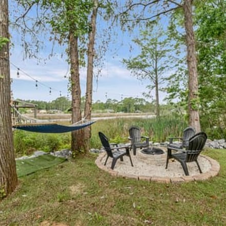 Hammock and fire pit in a shaded bayou backyard